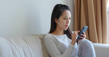 Kadın evde cep telefonu ile kağıt maskesi kullanın