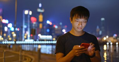 Adam gece şehirde cep telefonu kullanımı