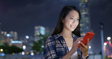 Kadın gece şehirde online cep telefonu kullanmak