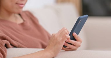 Evde cep telefonu kullanan bir kadın