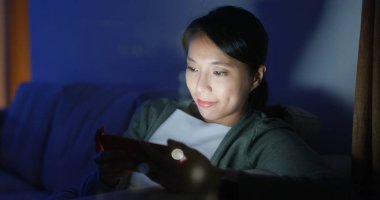 Kadın evde pencere cam yansıması ile cep telefonu kullanımı