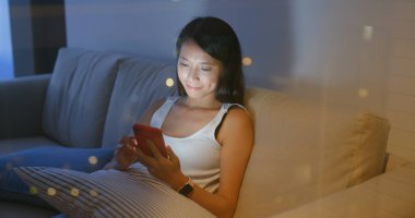 Kadın cep telefonu kullanmak ve evde akşamları oturun