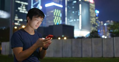 Adam gece şehirde cep telefonu kullanımı