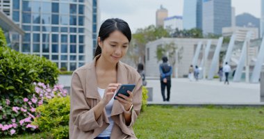 Kadın parkta cep telefonu kullanımı