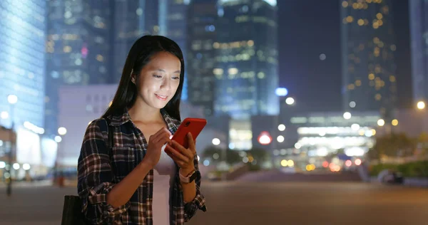 Woman use of mobile phone city night
