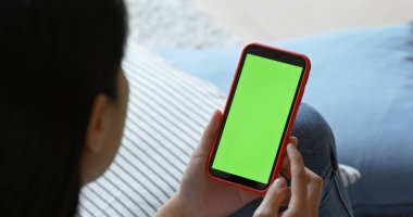 Yeşil ekranlı cep telefonu tutan kadın