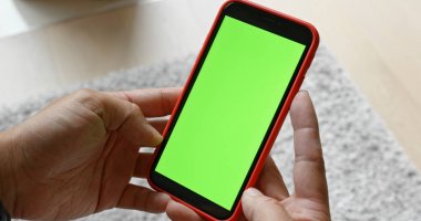 Cep telefonu ile yeşil ekran kullanan kadın