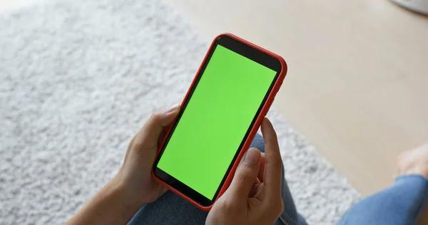 Woman holding cellphone with green screen