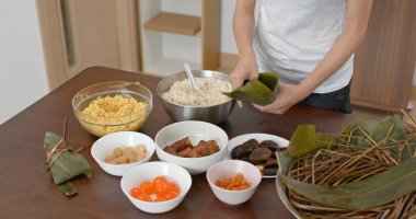 Kadın evde pirinç köftesi yapıyor.