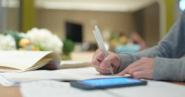 Mulher escreve na nota para estudar com celular — Fotografia de Stock