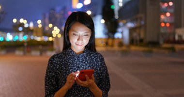 Asyalı kadın gece şehirde cep telefonu sms göndermek