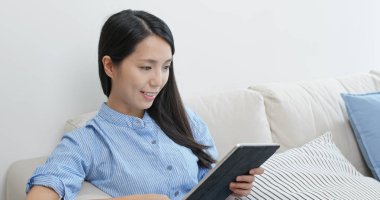 Evdeki tablet bilgisayarda çalışan kadın.