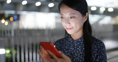 Geceleri kadın cep telefonu kullanıyor.