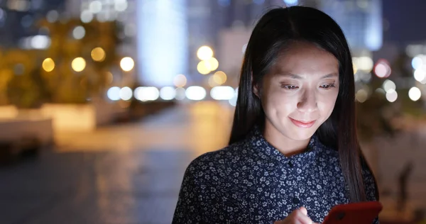 Woman read on mobile phone and sit outside