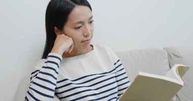 Woman read book and sit on sofa
