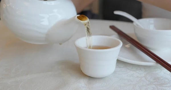 Verter té caliente en una taza en el restaurante chino — Foto de Stock