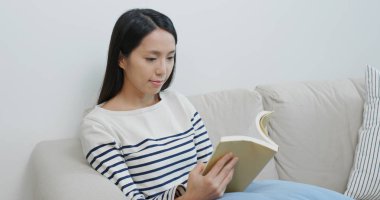 Woman read book and sit on sofa