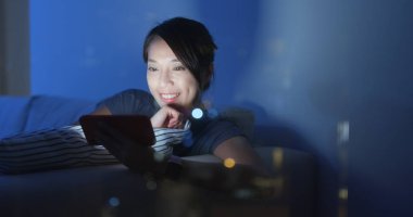 Pencereye bak. Kadın filmle birlikte cep telefonundan izliyor.