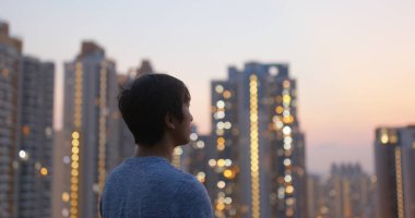 Adam gün batımıaltında gökdelen bakmak