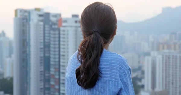 女人在晚上看香港的城市建筑 — 图库照片