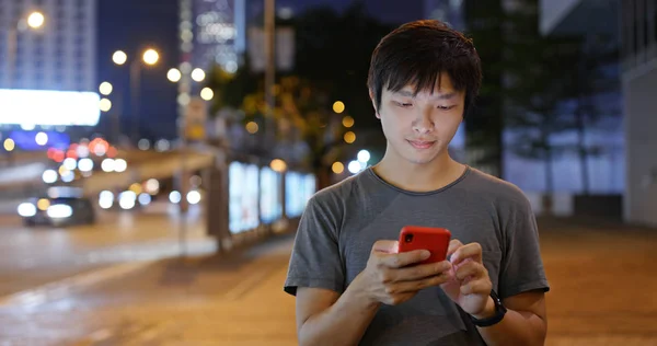 Man use of mobile phone in city at night