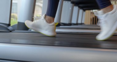 Kadın bacaklar spor salonunda koşu bandı üzerinde koşmak