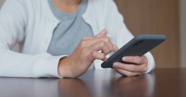 Evde cep telefonu kullanan bir kadın