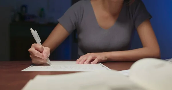 Woman write on the paper at home in the evening