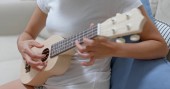 Žena praxe ukulele doma
