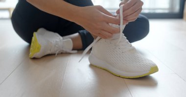 Evde spor ayakkabı giyen bir kadın.