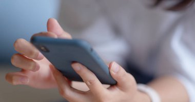 Evde cep telefonu kullanan bir kadın