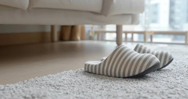家里的地毯上的灰色拖鞋 — 图库照片