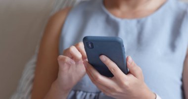 Evde akıllı telefon kullanan bir kadın.