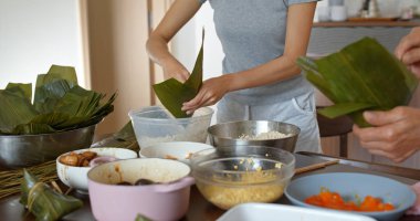 Kadın ejderha teknesi festivali için geleneksel pirinç köftesi yapıyor.