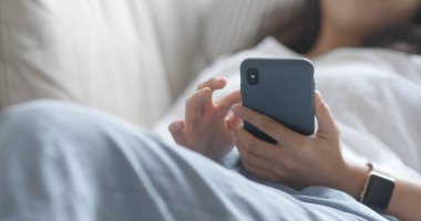 Evde cep telefonu kullanan bir kadın