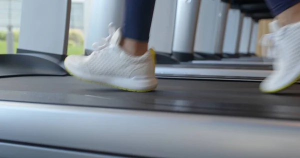 Kvinnliga ben springer på löpbandet i gymmet — Stockfoto