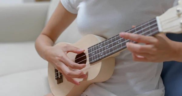 Kvinna praktiken ukulele hemma — Stockfoto
