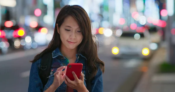 Mulher uso de telefone inteligente na cidade à noite — Fotografia de Stock