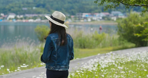 女性は風景を見回し 木製のベンチに座ります — ストック写真