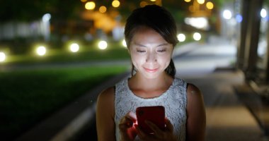 Geceleri kadın cep telefonu kullanıyor.