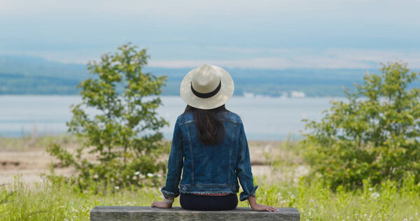 Woman look around and sit on the wooden bench