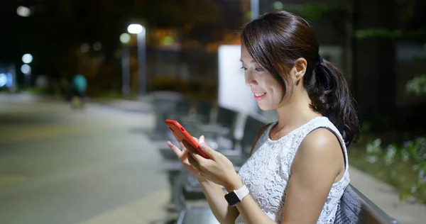 Kvinna titta på mobiltelefon på Park — Stockfoto