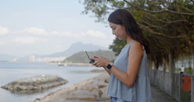 Kadın drone uçmak ve deniz kenarında durmak