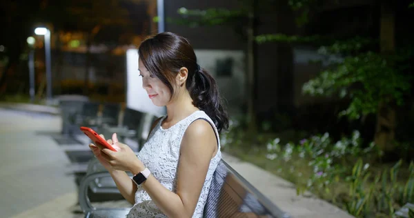 Femme utilisation du téléphone intelligent dans la ville dans la soirée — Photo