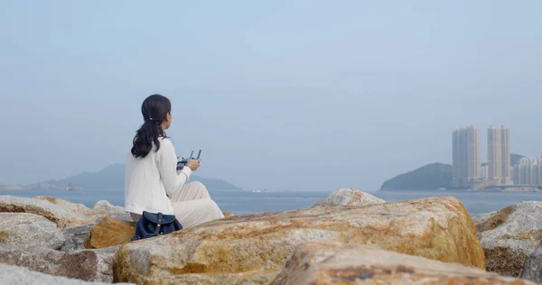 La donna controlla un drone al mare — Foto Stock