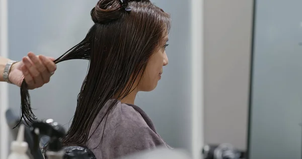 Женщина делает прямые волосы — стоковое фото