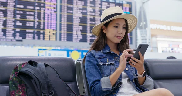 Kvinna användning av smarttelefon för att kontrollera flygschemat i luften — Stockfoto