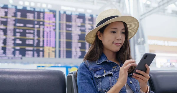 女性は空港の携帯電話で飛行スケジュールを確認します — ストック写真