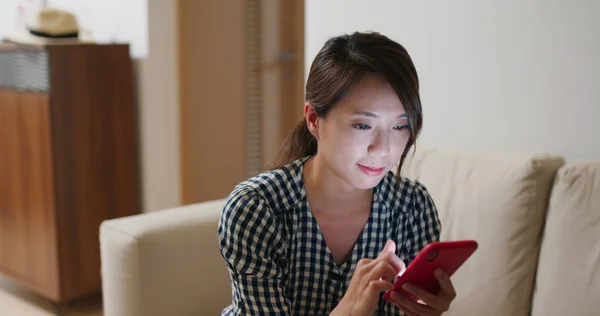 Frau nutzt Handy abends zu Hause — Stockfoto