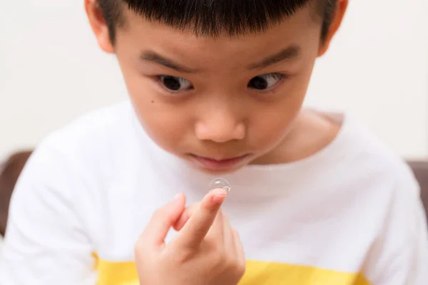 Jeune enfant tenir avec une lentille de contact — Photo